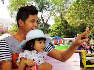 Man holding small girl wearing a hat